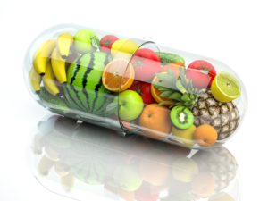 Vitaminkapsel mit Obst und Gemüse für eine ausgewogene Ernährung.